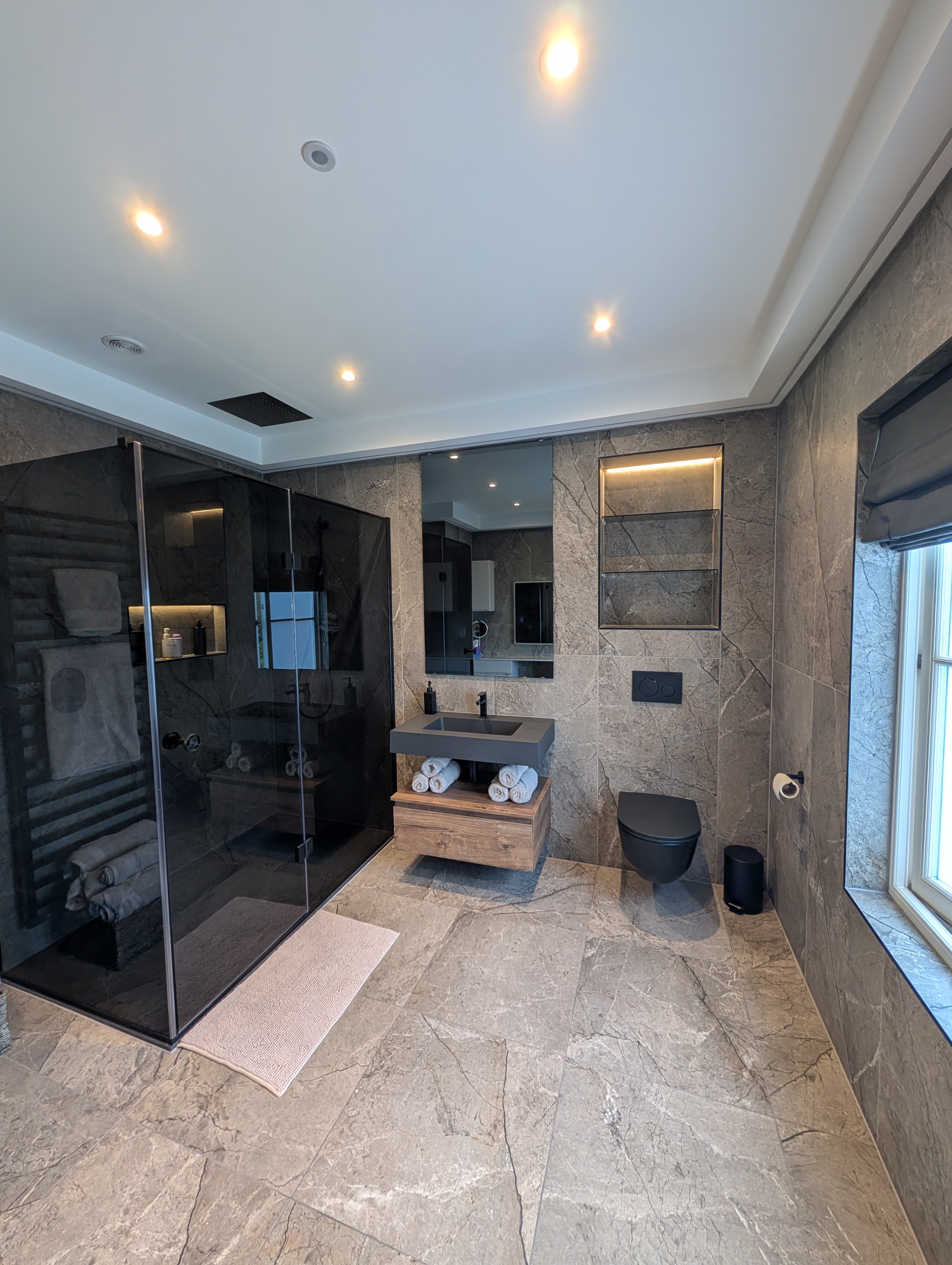 Premium ensuite installation in Stoke-on-Trent with dark stone-effect tiling and walk-in shower