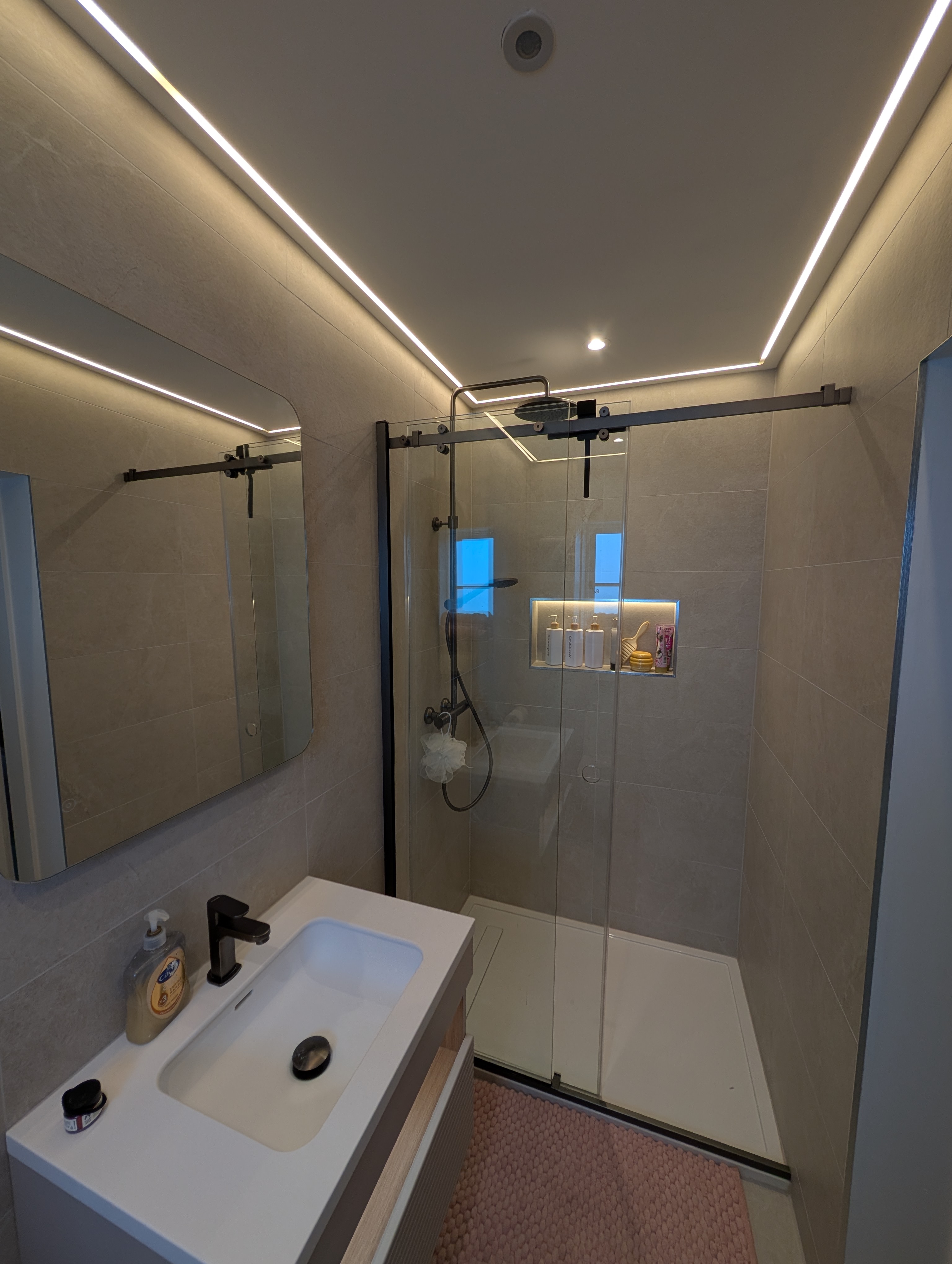 Modern ensuite installation with walk-in shower and LED ceiling detail